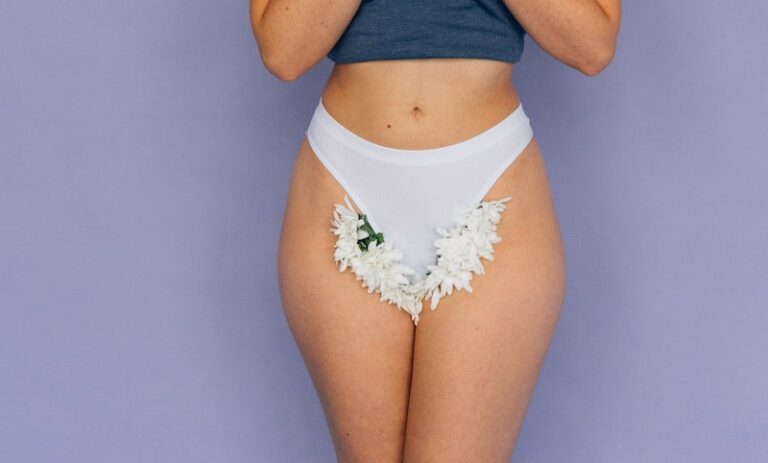 A Woman Wearing White Panty with Flowers Between Her Legs